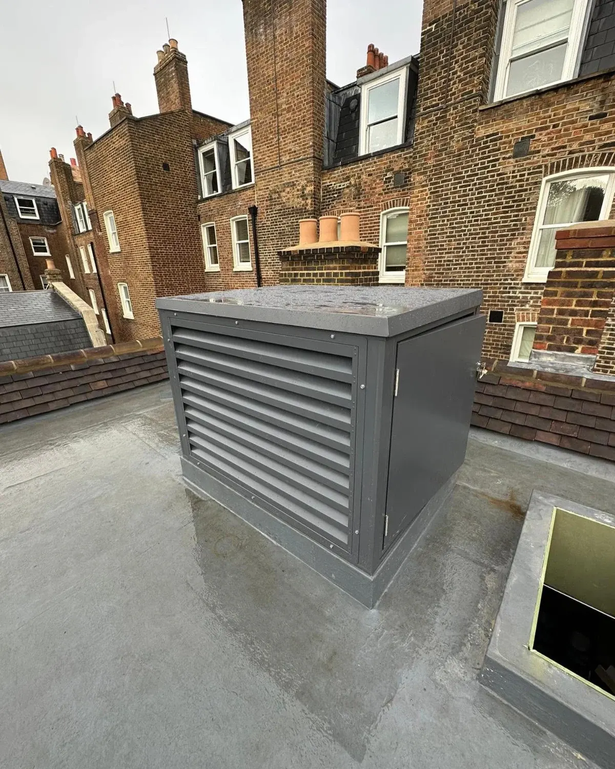 Louvred acoustic enclosure housing a rooftop unit on a London property